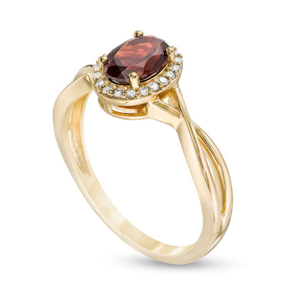 Oval Garnet and 0.07 CT. T.W. Natural Diamond Frame Twist Shank Ring in Solid 10K Yellow Gold