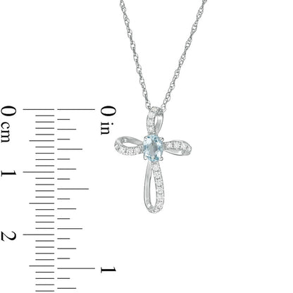 Oval Aquamarine and 0.1 CT. T.W. Natural Diamond Pinwheel Cross Pendant in 10K White Gold